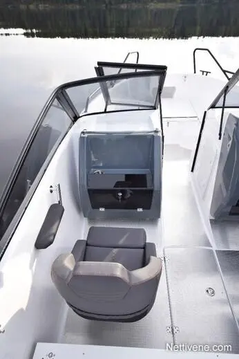 A sleek boat interior showcasing a comfortable gray seating area, a clear windshield, and a storage compartment.